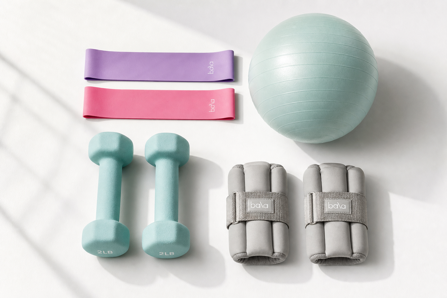 Flat lay of seated exercise equipment including resistance bands, light dumbbells, and an exercise ball