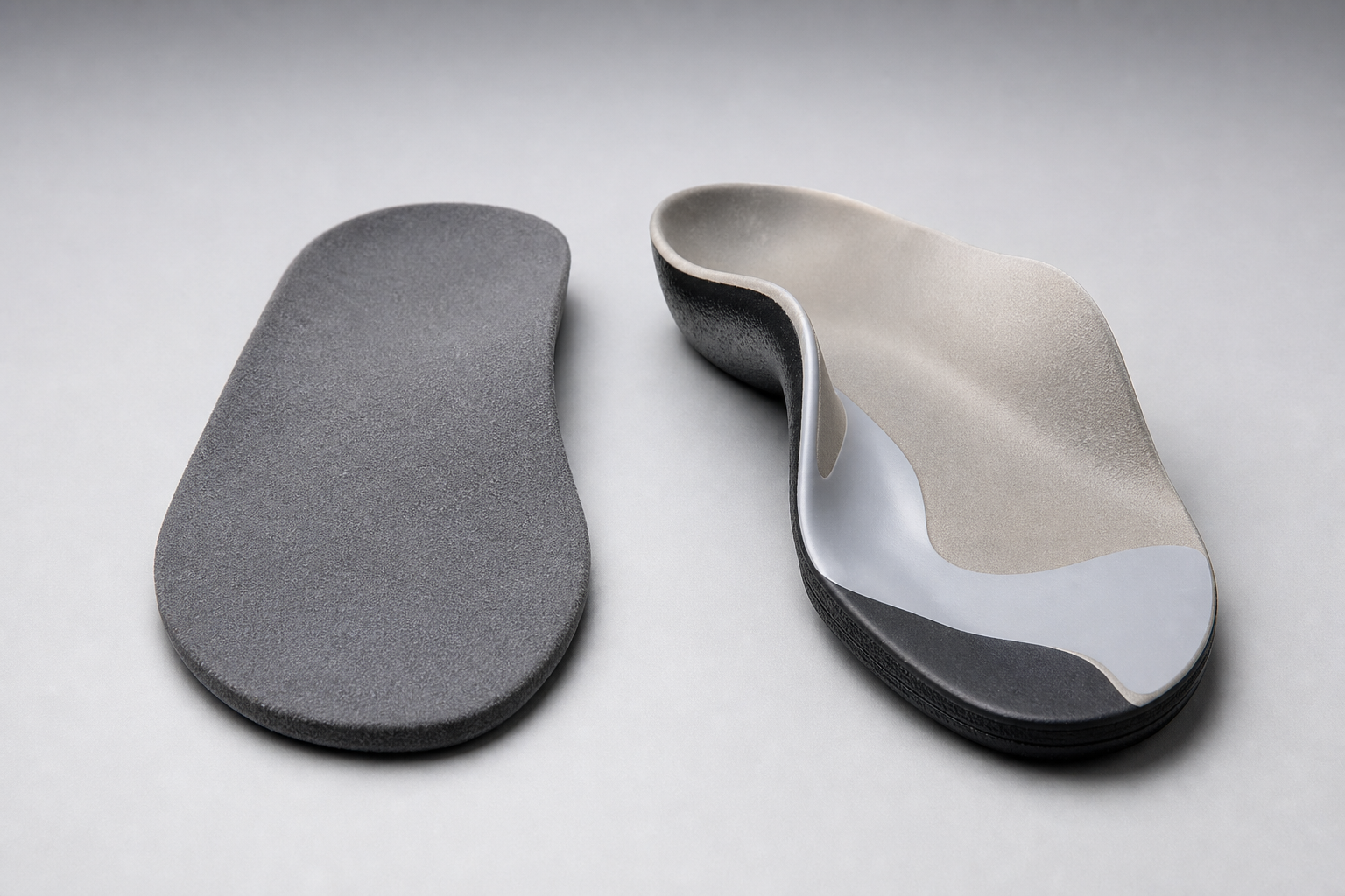 A standard over-the-counter insole placed next to a custom orthotic showing clear differences in structure and detail