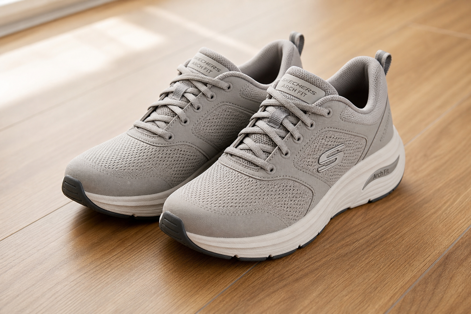 A pair of supportive, cushioned walking shoes on a wooden floor