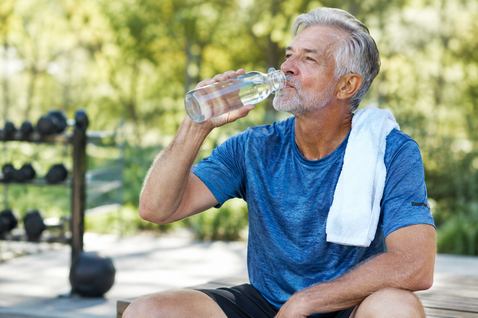 Senior man drinking water from a bottle after exercise to stay hydrated
